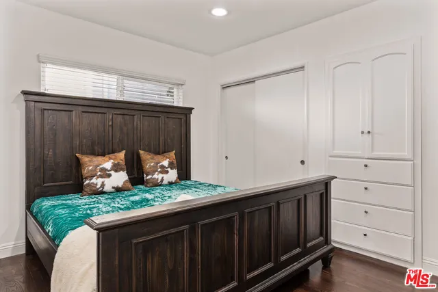 a bedroom with a large bed and a painting on the wall