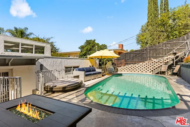 a view of a chairs and table in the backyard