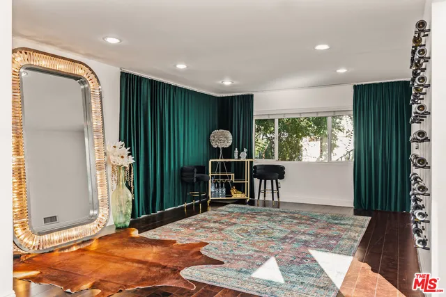 a view of a hallway to a livingroom with furniture and window