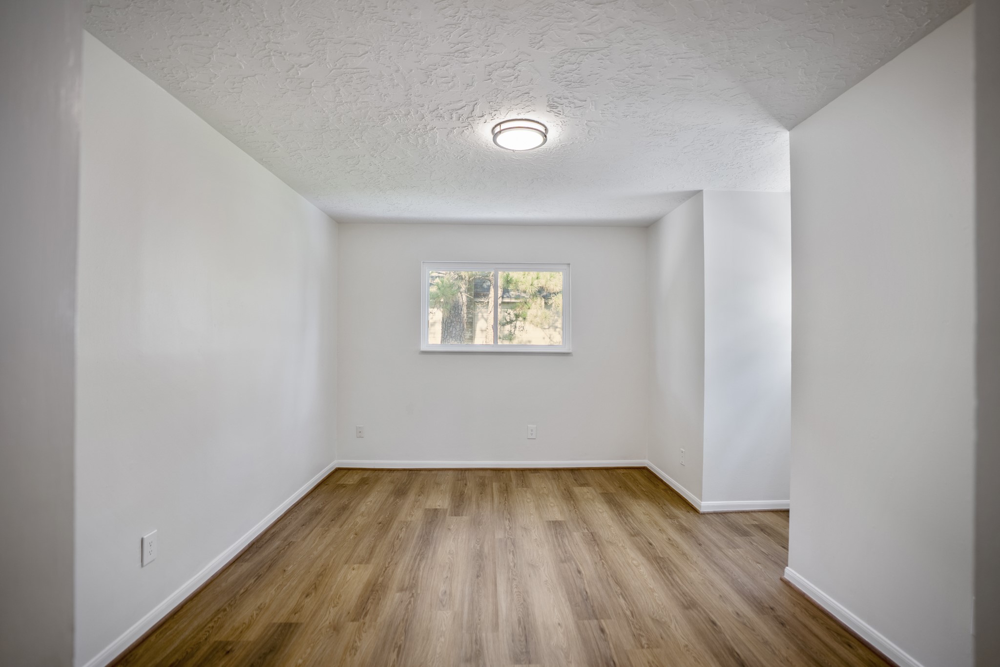 6303 Larkmount Drive Spring, TX 77389 - Photo 29 of 50 Continuing down the upstairs hall, the first bedroom adds a little extra character with its dormer-style pop-out creating a defined nook near the window. Dual closets add practical storage, while the updated flooring and fresh paint keep the upstairs feeling clean and refreshed.