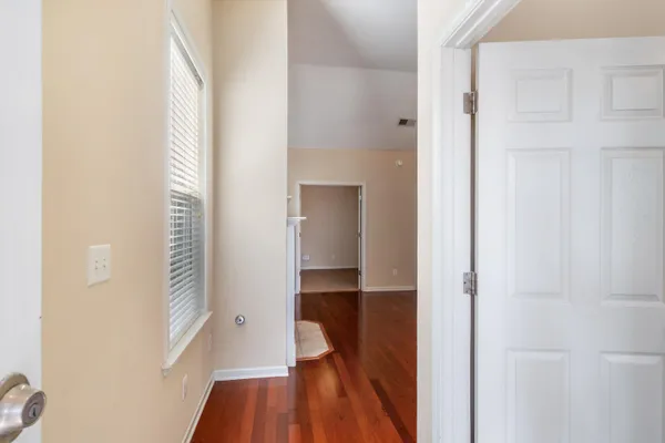 a view of a hallway with wooden floor and staircase