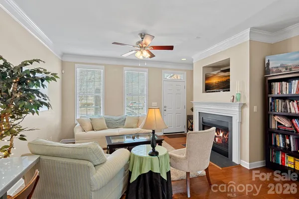 a living room with furniture a bookshelf and a window
