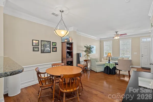 a dining room with furniture a chandelier and wooden floor
