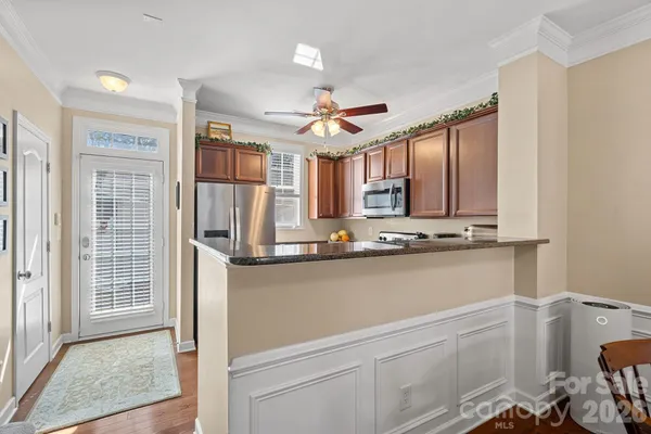 a kitchen with stainless steel appliances granite countertop a sink and a refrigerator