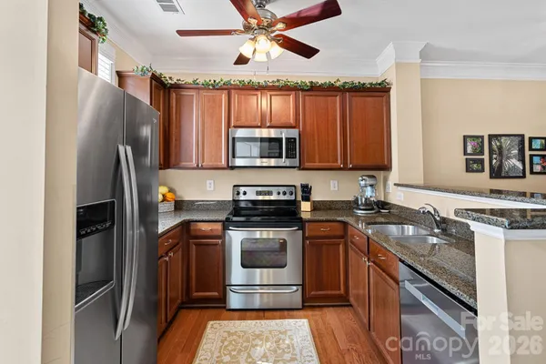 a kitchen with stainless steel appliances granite countertop a stove a refrigerator and a sink
