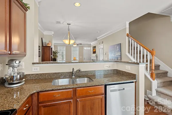 a kitchen with granite countertop a sink a stove and cabinets