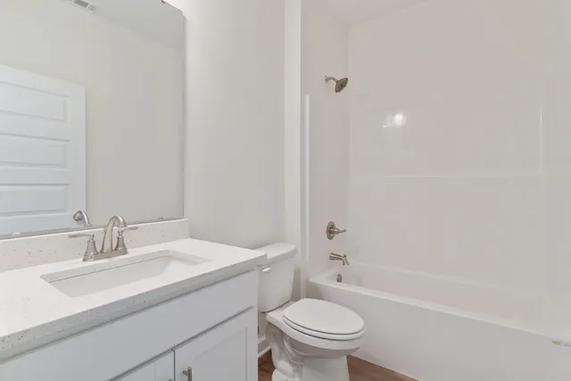 a bathroom with a sink toilet vanity and bathtub