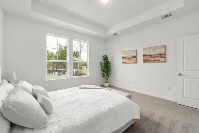 a large bed sitting in a bedroom next to a window