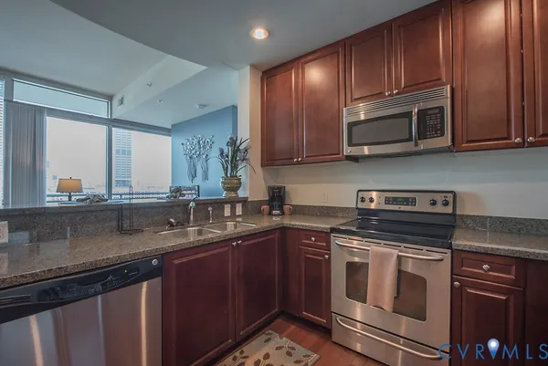 a kitchen with stainless steel appliances granite countertop a sink stove and microwave