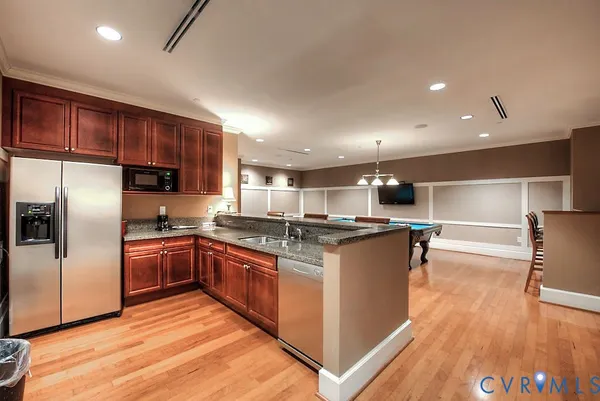a kitchen with stainless steel appliances granite countertop a sink and refrigerator