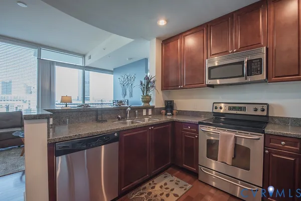 a kitchen with stainless steel appliances granite countertop a sink stove and microwave