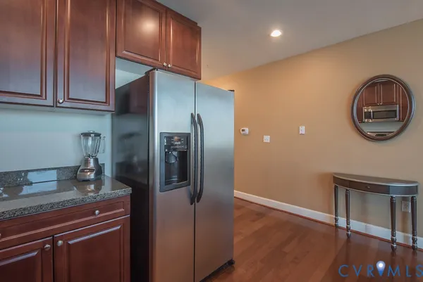 a kitchen with stainless steel appliances granite countertop a refrigerator and a stove top oven