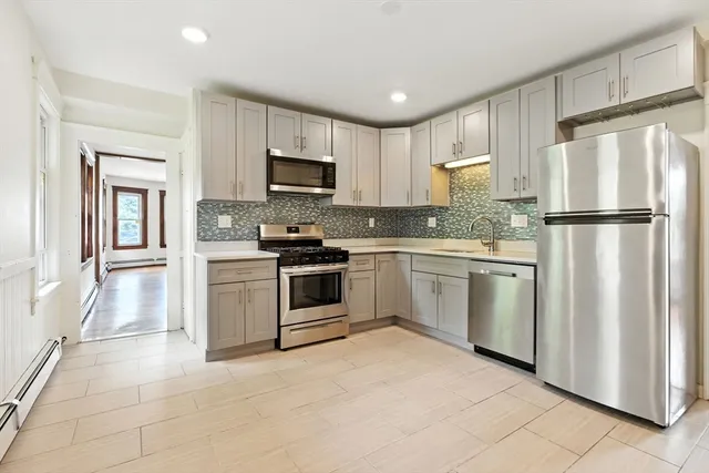 a kitchen with white cabinets and white appliances