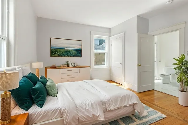 a spacious bedroom with a bed and a flat screen tv