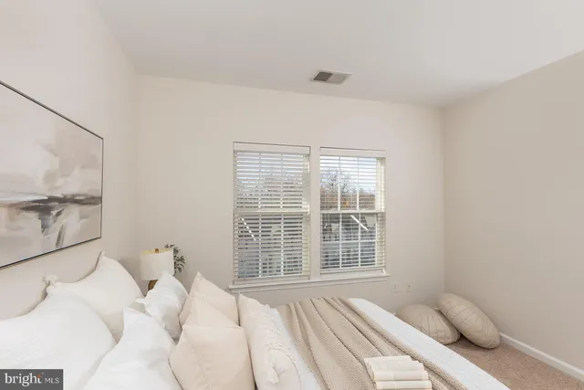 a bedroom with a bed and a large window