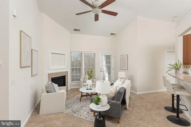 a living room with furniture fireplace and a large window