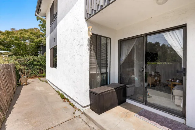 a view of a balcony with a potted plant and glass door
