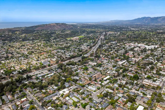 an aerial view of residential house with parking and yard