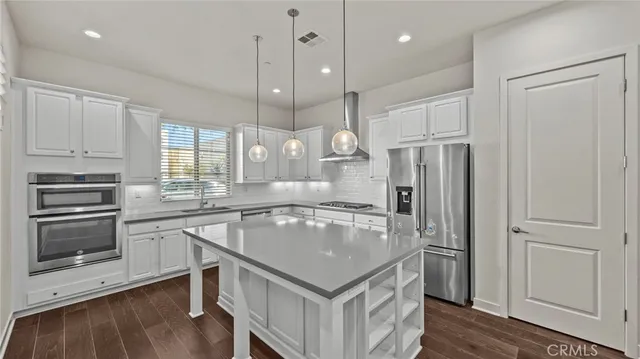 a kitchen with a refrigerator a sink and wooden floor