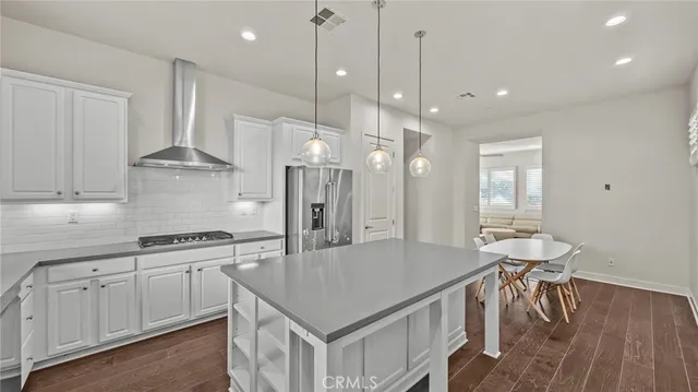 a kitchen with stainless steel appliances granite countertop a stove a sink refrigerator and a wooden cabinets