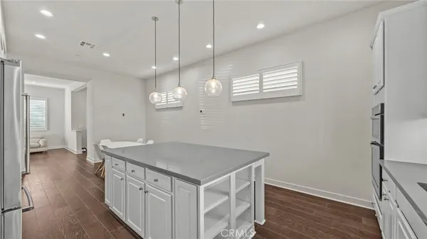 a kitchen with a sink a refrigerator and wooden floor