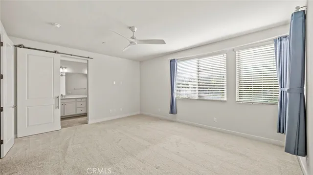 a view of an empty room with a window and a kitchen