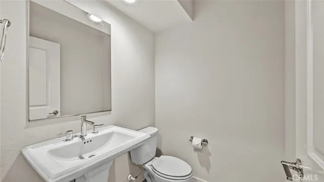 a bathroom with a sink toilet and a mirror