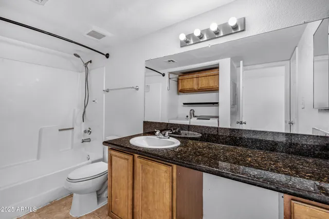 a bathroom with a granite countertop sink toilet and shower