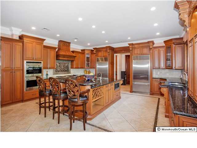 34 Line Road Holmdel, NJ 07733 - Photo 10 of 25 a kitchen with stainless steel appliances kitchen island granite countertop a refrigerator and a stove top oven
