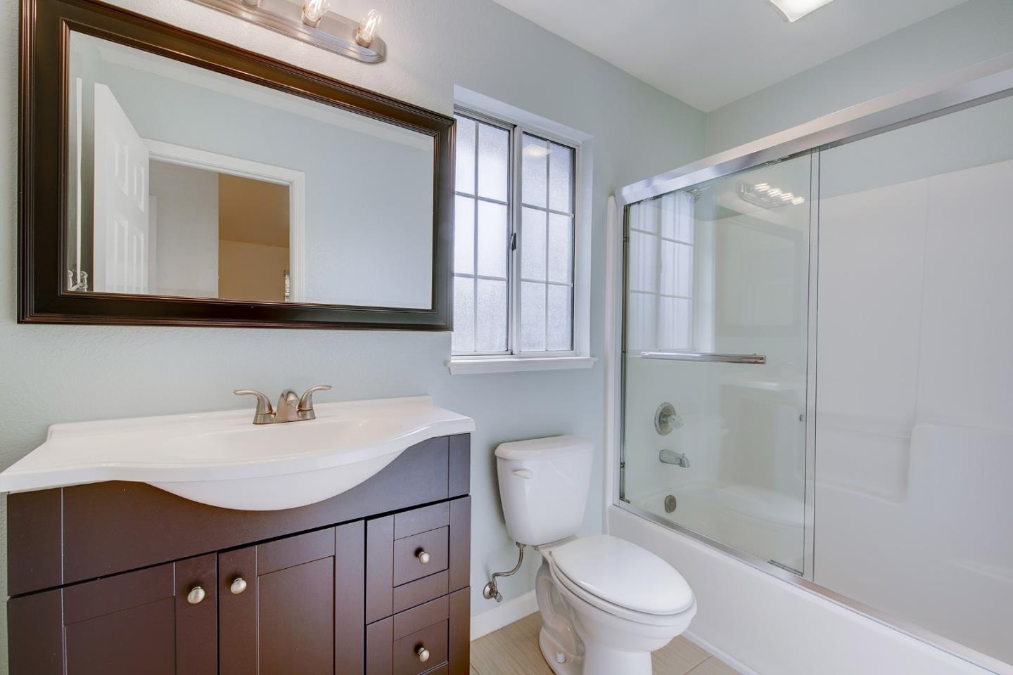 1013 Woodside Road Redwood City, CA 94061 - Photo 16 of 20 a bathroom with a sink a toilet and shower