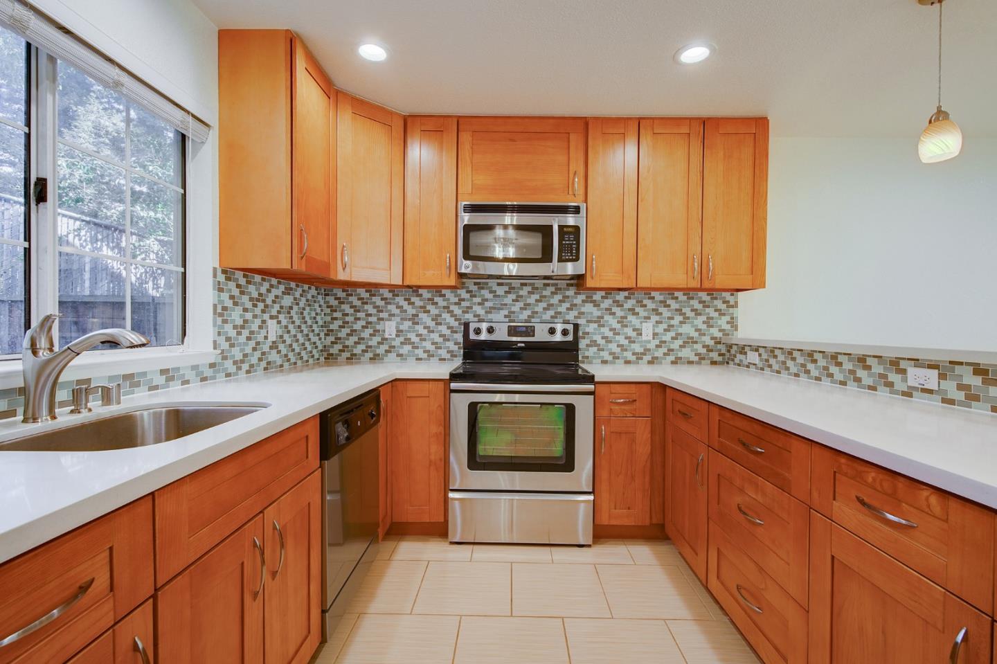 1013 Woodside Road Redwood City, CA 94061 - Photo 6 of 20 a kitchen with stainless steel appliances wooden cabinets and a sink