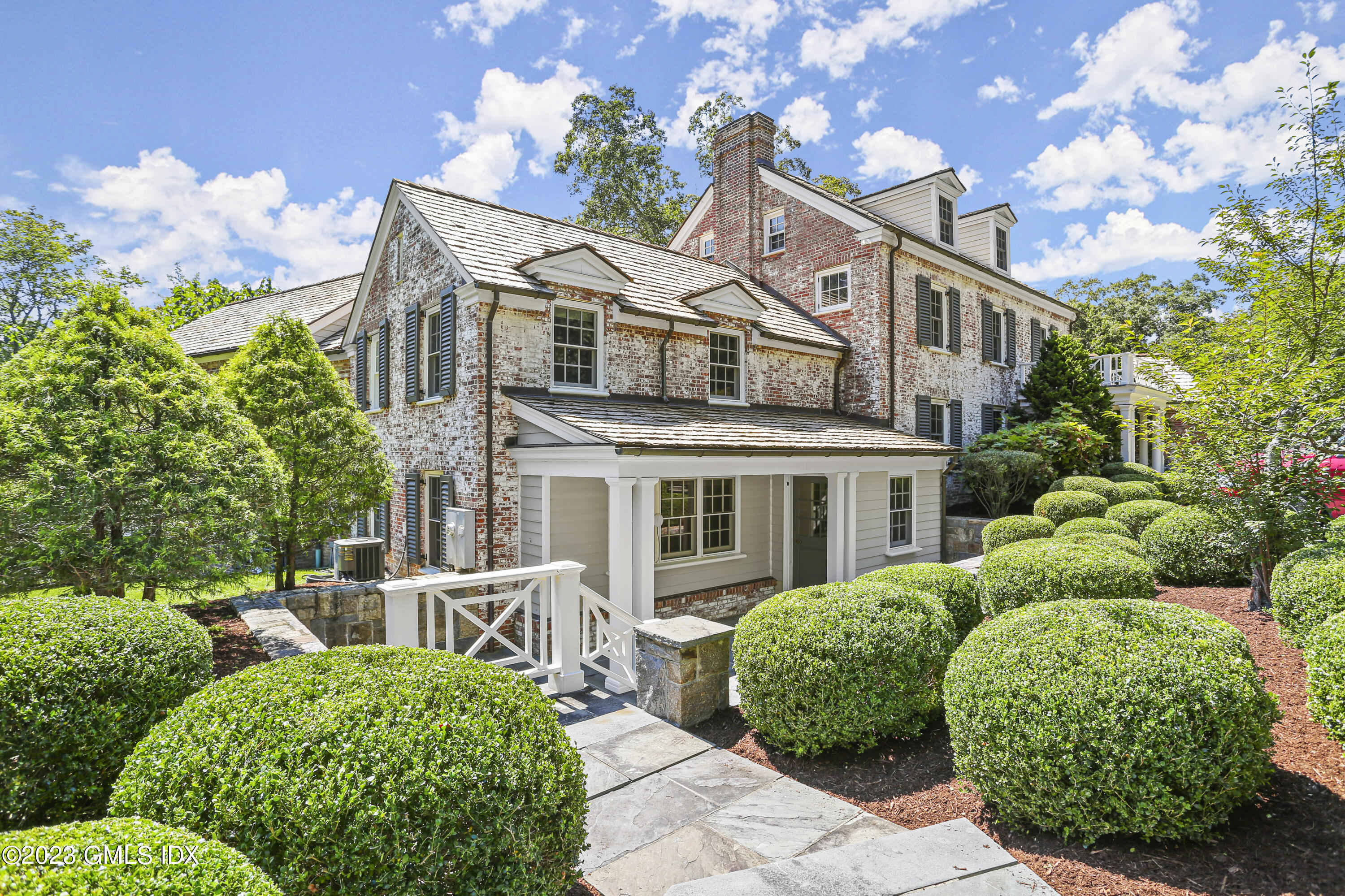 26 Memory Lane Greenwich, CT 06831 - Photo 2 of 43 a view of a white house with a small yard and plants