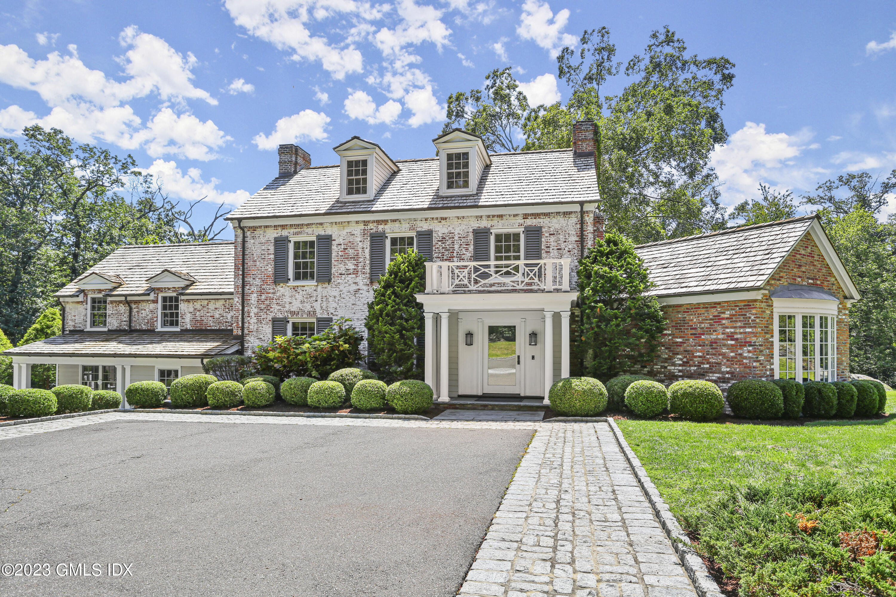 26 Memory Lane Greenwich, CT 06831 - Photo 35 of 43 a front view of a house with a yard and potted plants