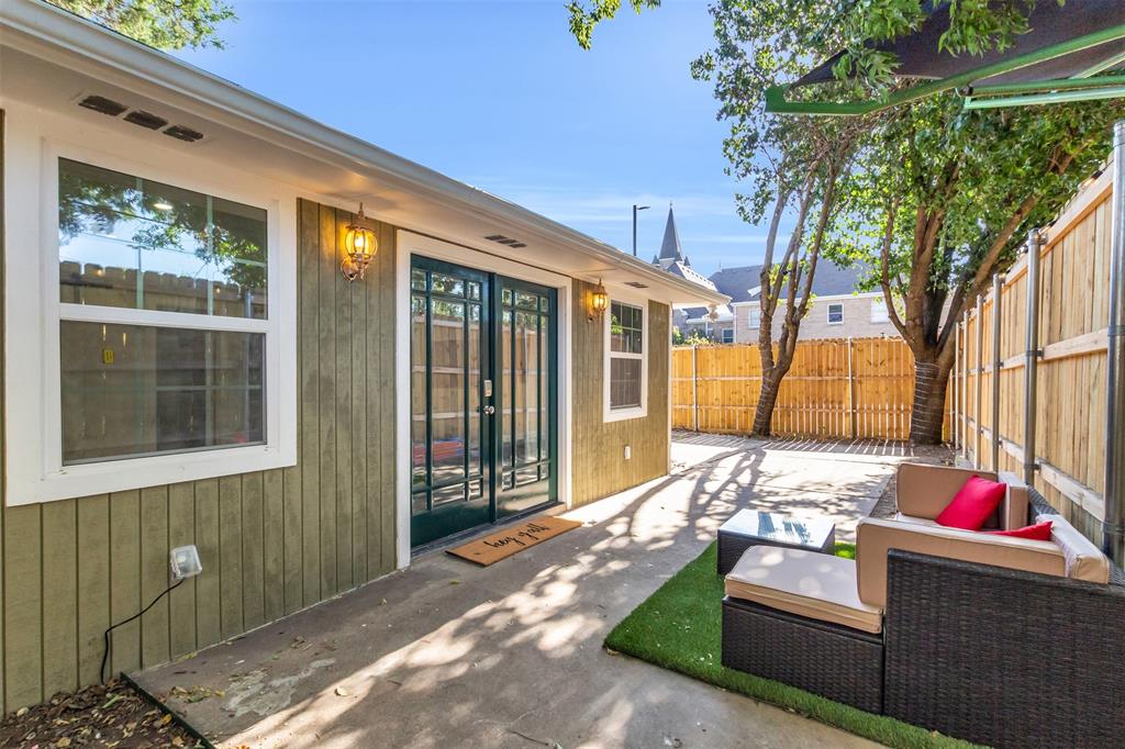 4121 Junius Street, Unit B Dallas, TX 75246 - Photo 2 of 32 Backyard patio featuring a concrete slab, artificial turf, and a wood privacy fence