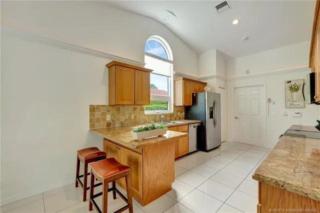 a kitchen with stainless steel appliances granite countertop a stove a sink and a refrigerator