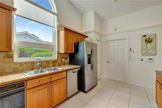 a kitchen with stainless steel appliances granite countertop a refrigerator and a sink