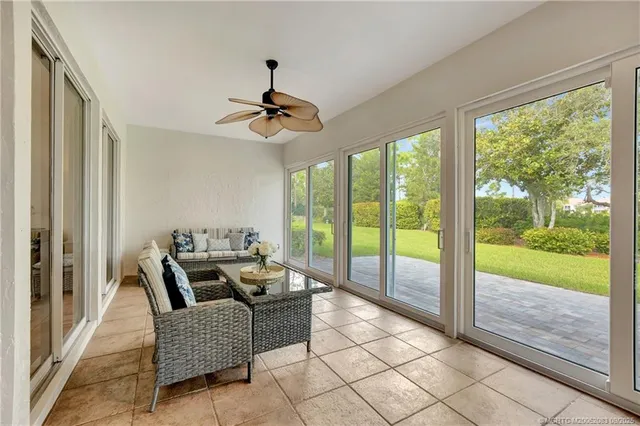a dining room with furniture and a floor to ceiling window