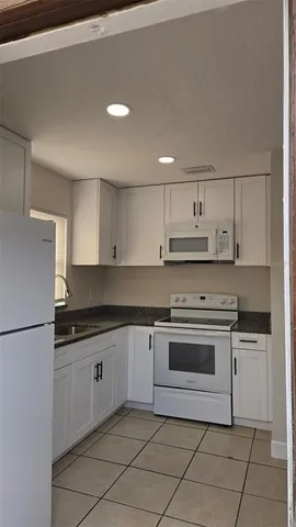 a kitchen with granite countertop a sink stainless steel appliances and cabinets