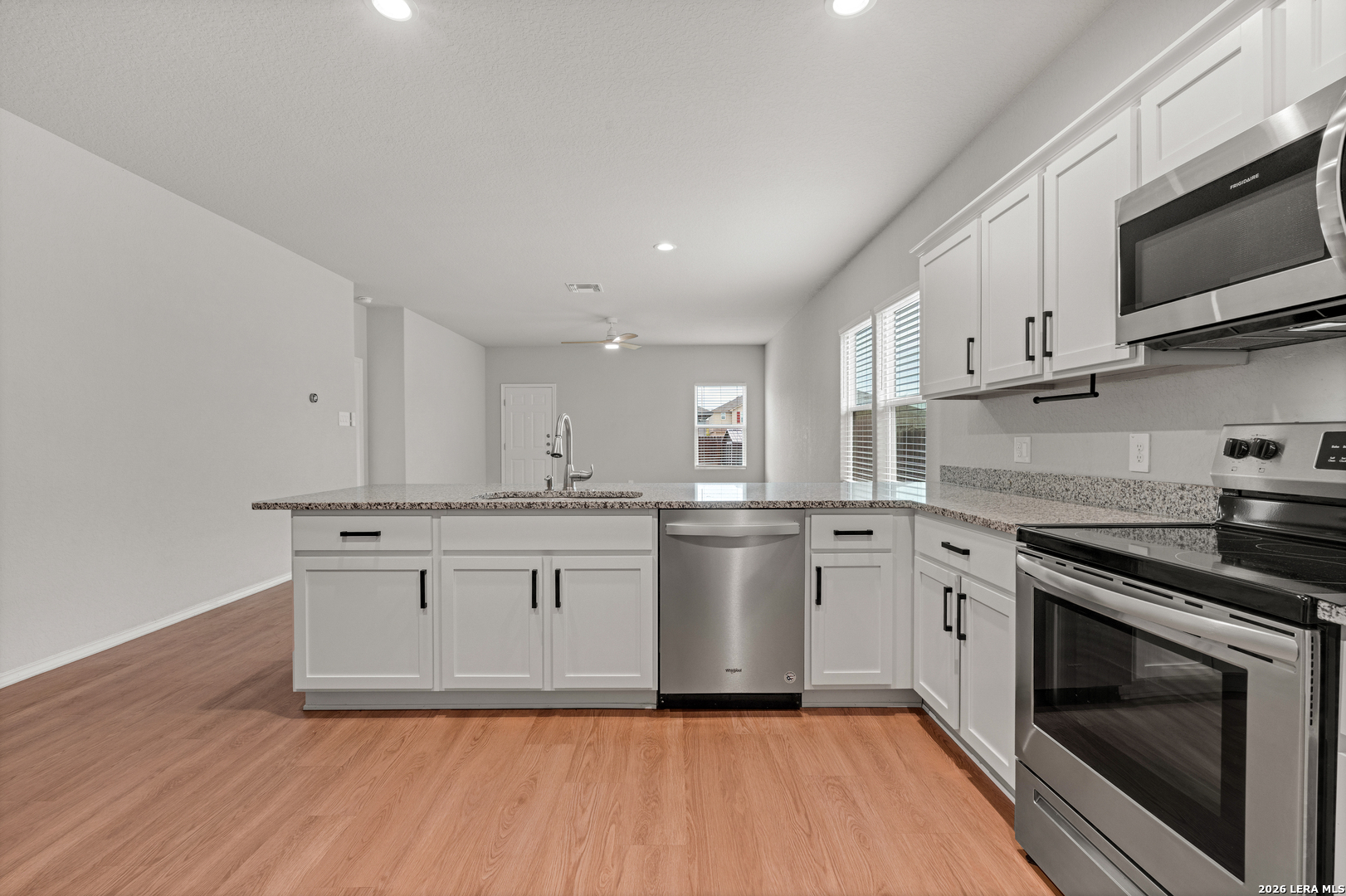 14606 Hackamore Way Elmendorf, TX 78112 - Photo 2 of 18 a kitchen with stainless steel appliances granite countertop a stove a sink and a microwave