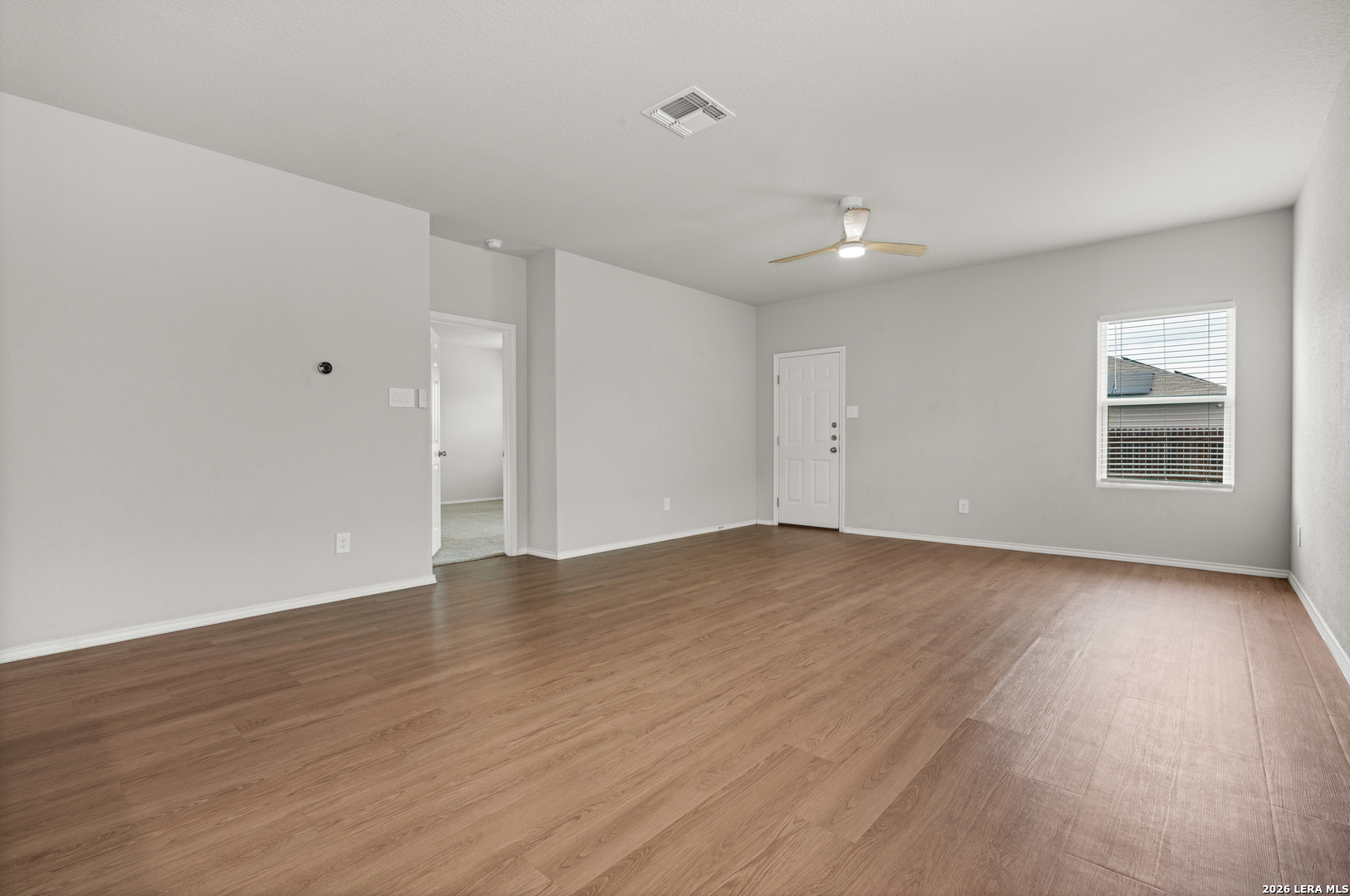 14606 Hackamore Way Elmendorf, TX 78112 - Photo 4 of 18 a view of empty room with wooden floor and fan