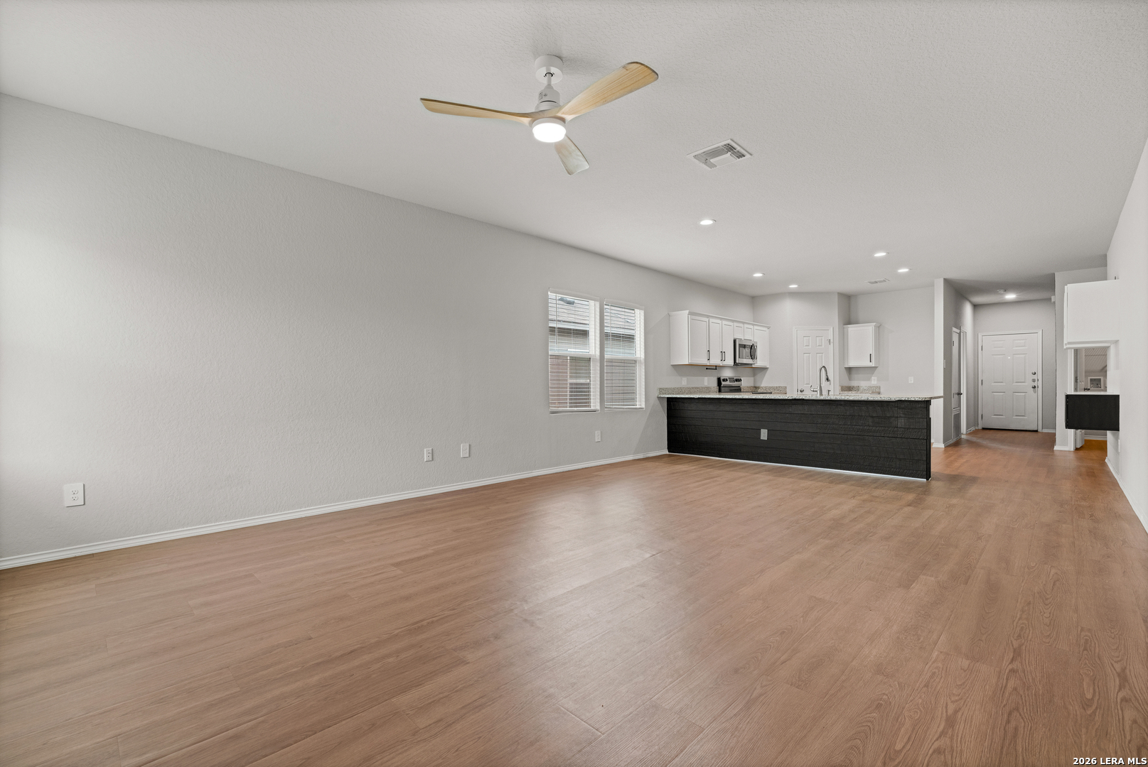 14606 Hackamore Way Elmendorf, TX 78112 - Photo 5 of 18 a view of an empty room with a kitchen