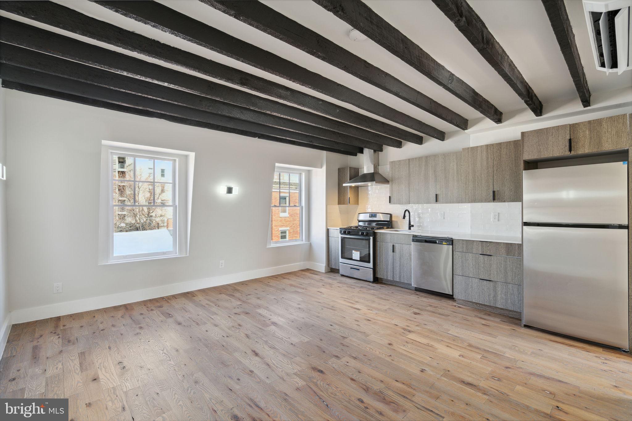 a kitchen with a refrigerator a sink and dishwasher with wooden floor