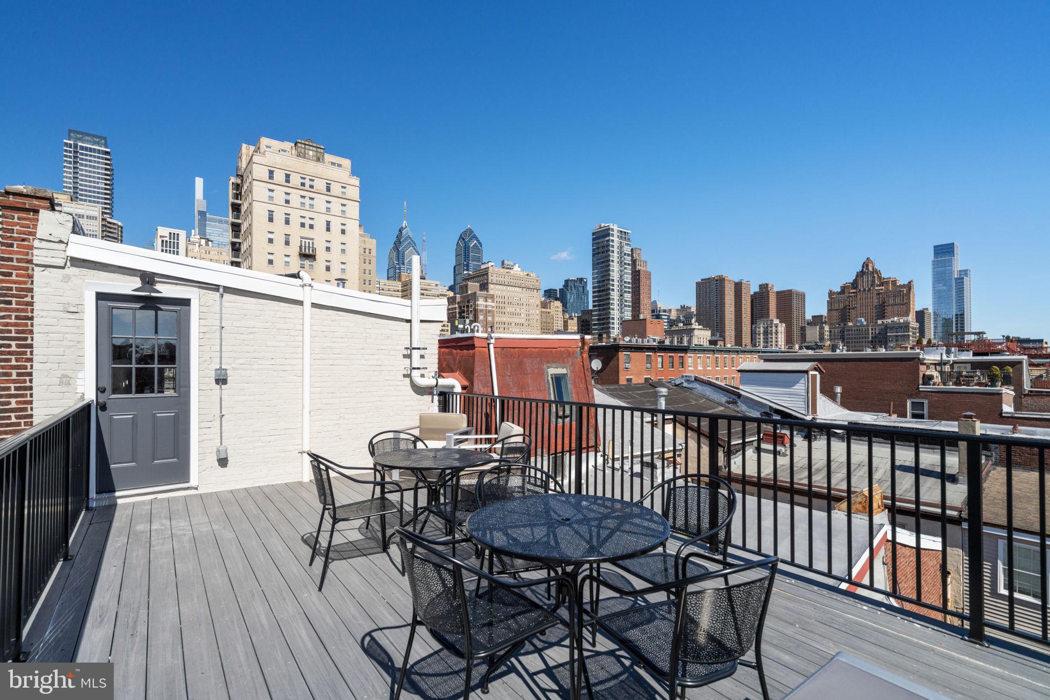 1908 Pine Street, Unit 6 Philadelphia, PA 19103 - Photo 15 of 24 a view of a rooftop deck with chairs and wooden floor