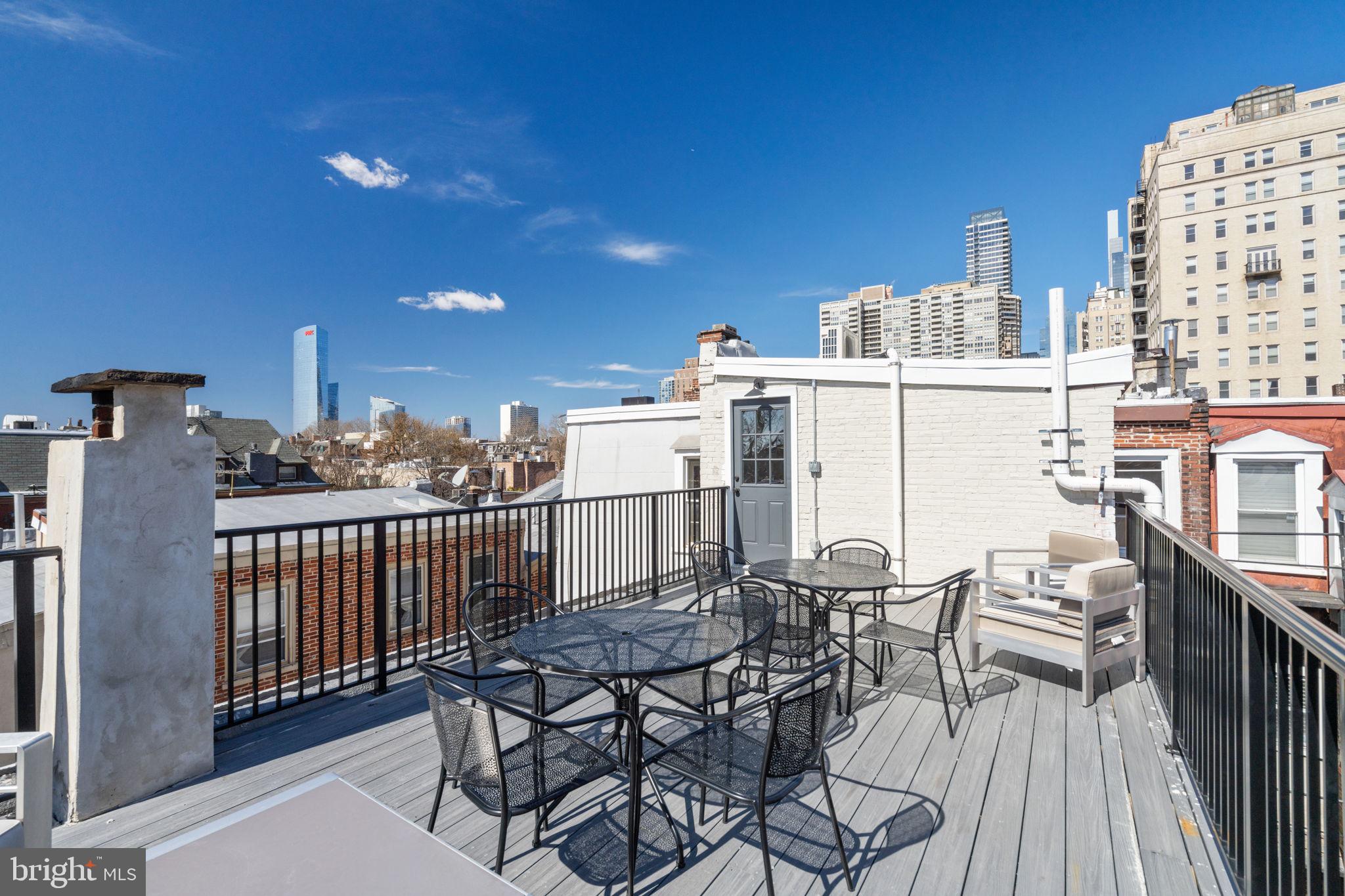 1908 Pine Street, Unit 6 Philadelphia, PA 19103 - Photo 16 of 24 a view of a roof deck with table and chairs with wooden floor and fence