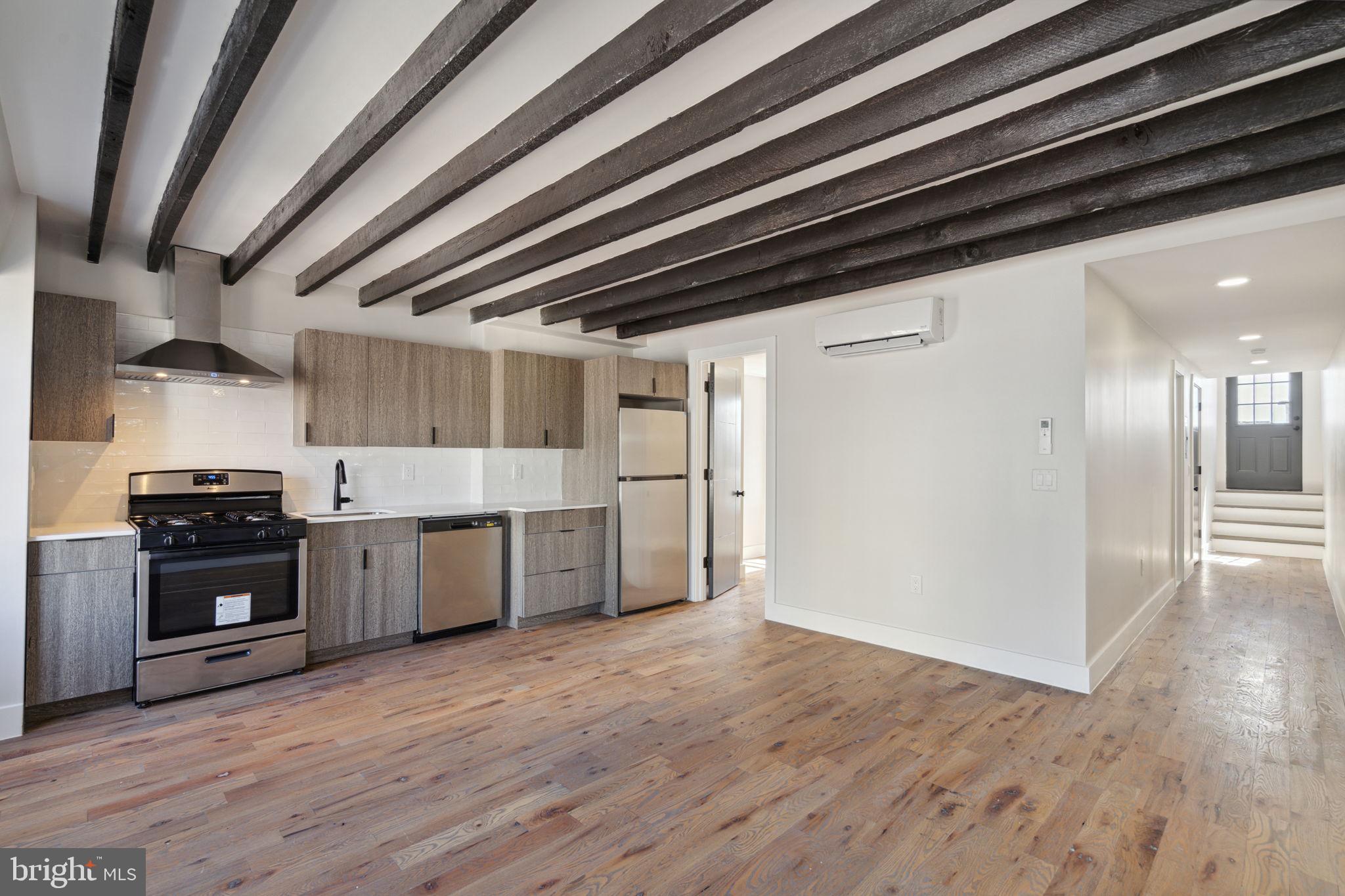 1908 Pine Street, Unit 6 Philadelphia, PA 19103 - Photo 3 of 24 a large kitchen with stainless steel appliances granite countertop a wooden floors and granite counter tops