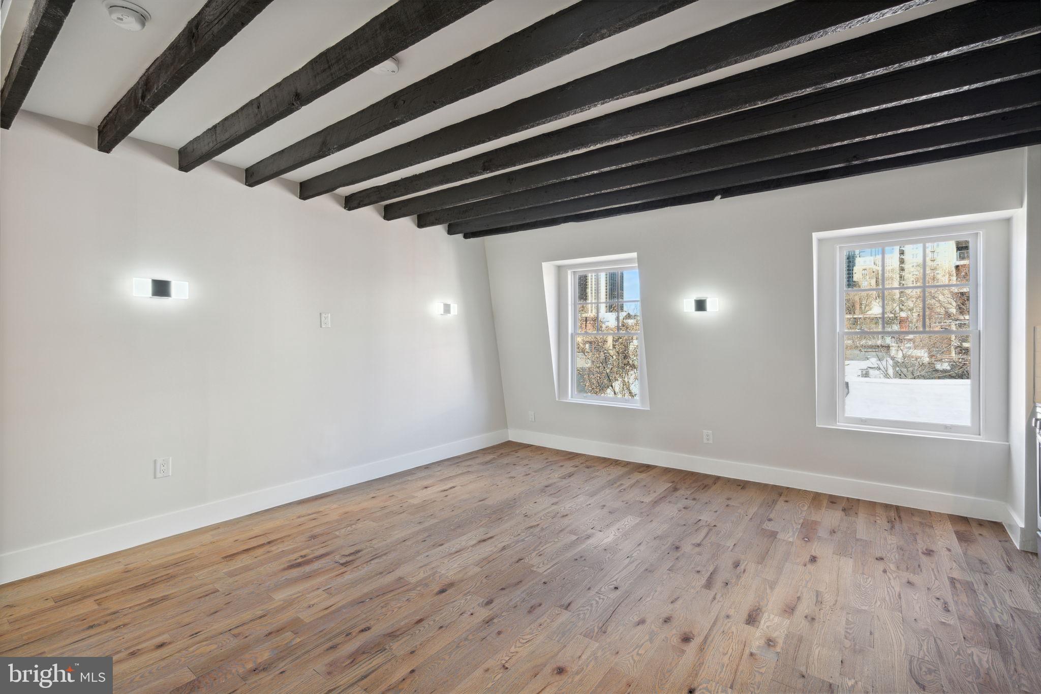 1908 Pine Street, Unit 6 Philadelphia, PA 19103 - Photo 5 of 24 a view of an empty room with wooden floor and a window