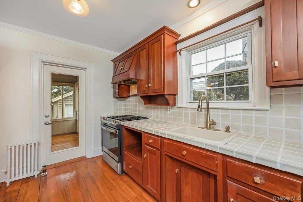 315 Marcellus Road Mineola, NY 11501 - Photo 8 of 18 a kitchen with stainless steel appliances granite countertop a sink a stove and a wooden floors