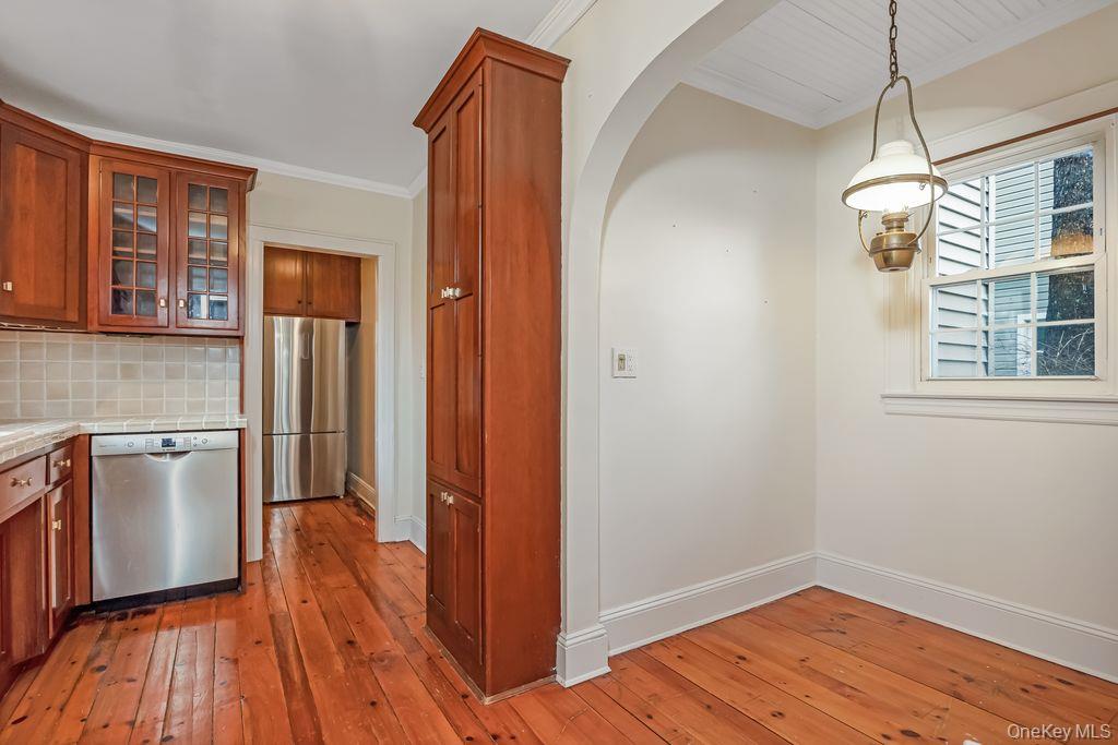 315 Marcellus Road Mineola, NY 11501 - Photo 9 of 18 a view of a kitchen with a refrigerator a sink wooden floor and a window