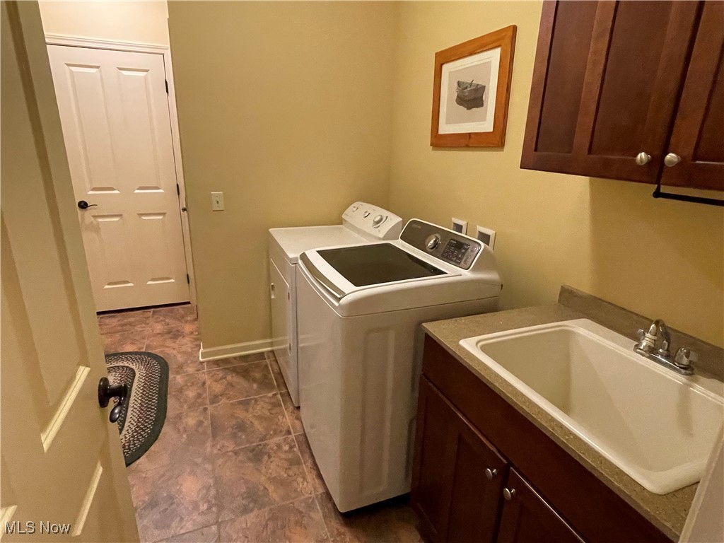 8322 Forest Ridge Street Northwest Massillon, OH 44646 - Photo 31 of 33 Washroom with independent washer and dryer, cabinet space, and dark tile patterned flooring