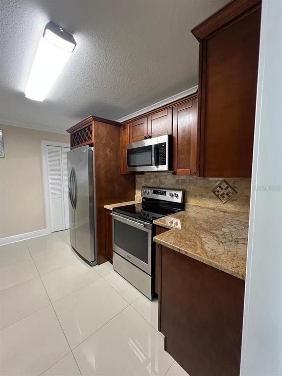 5602 Joyner Road Tampa, FL 33624 - Photo 18 of 28 a kitchen with stainless steel appliances granite countertop a refrigerator and a stove top oven